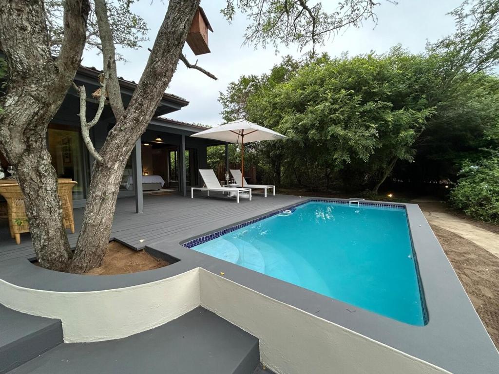 a swimming pool in front of a house at The Cabin Luxury Safari Villa in Somerset