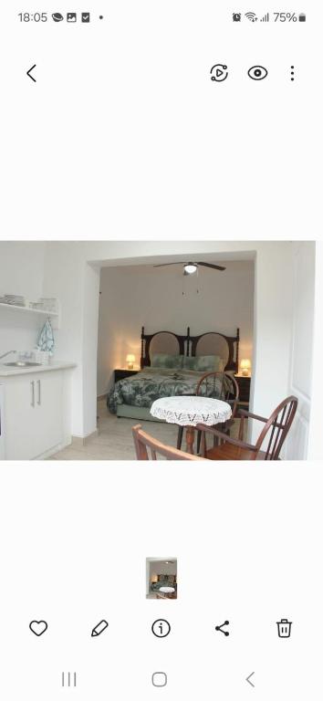 a room with a bed and a table and chairs at Weltevrede guest unit in Mossel Bay