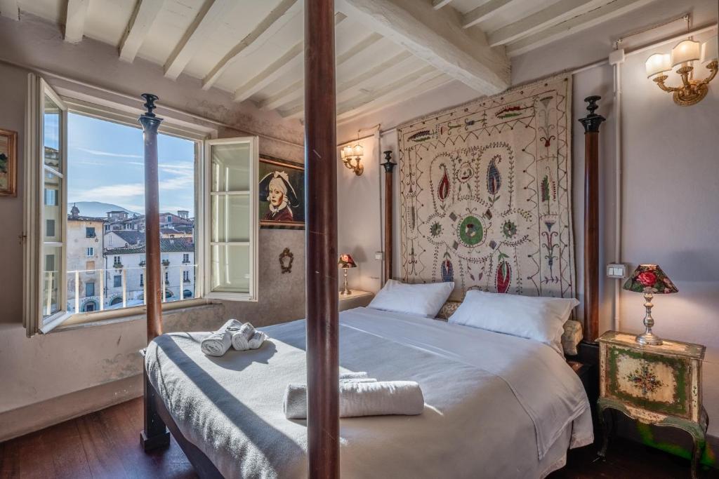 a bedroom with a large bed and a large window at Il Mazzocchio - Lucca Centro in Lucca