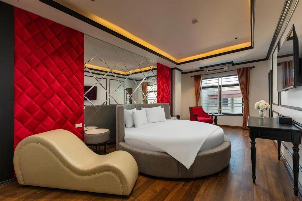 a bedroom with a large white bed and a desk at Grand Vĩnh Tuy Hanoi Hotel&Spa in Mai Phúc