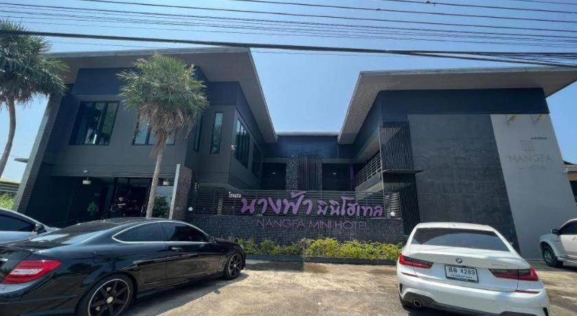 two cars parked in a parking lot in front of a house at Nangfa Mini Hotel in Ban Pa Kwao