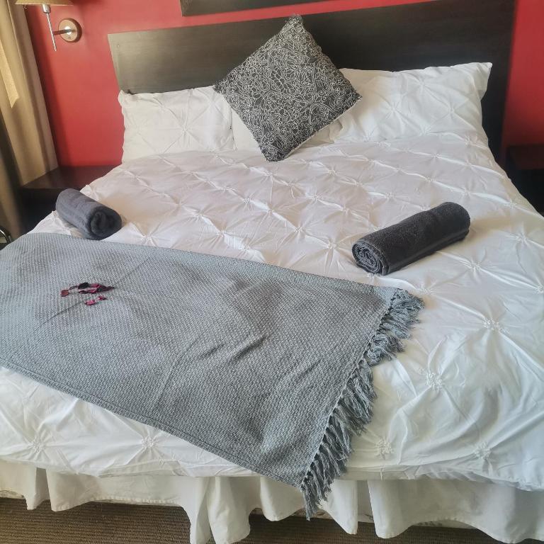 a white bed with two pillows and a blanket at Arkenstone Frys in Gqeberha