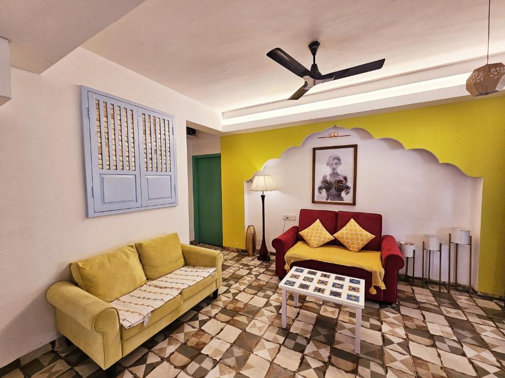 een woonkamer met een bank en een tafel bij Spacious Condo with Pool View in Anjuna