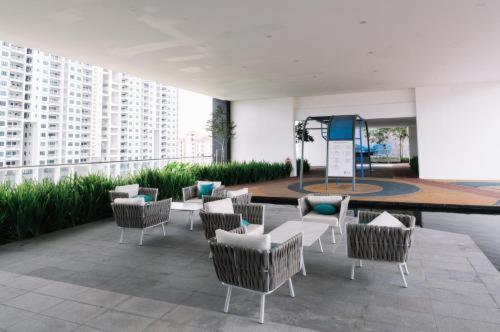 eine Gruppe von Stühlen und Tischen in einem Gebäude in der Unterkunft Urban Suites Apartment In Jelutong George Town in George Town