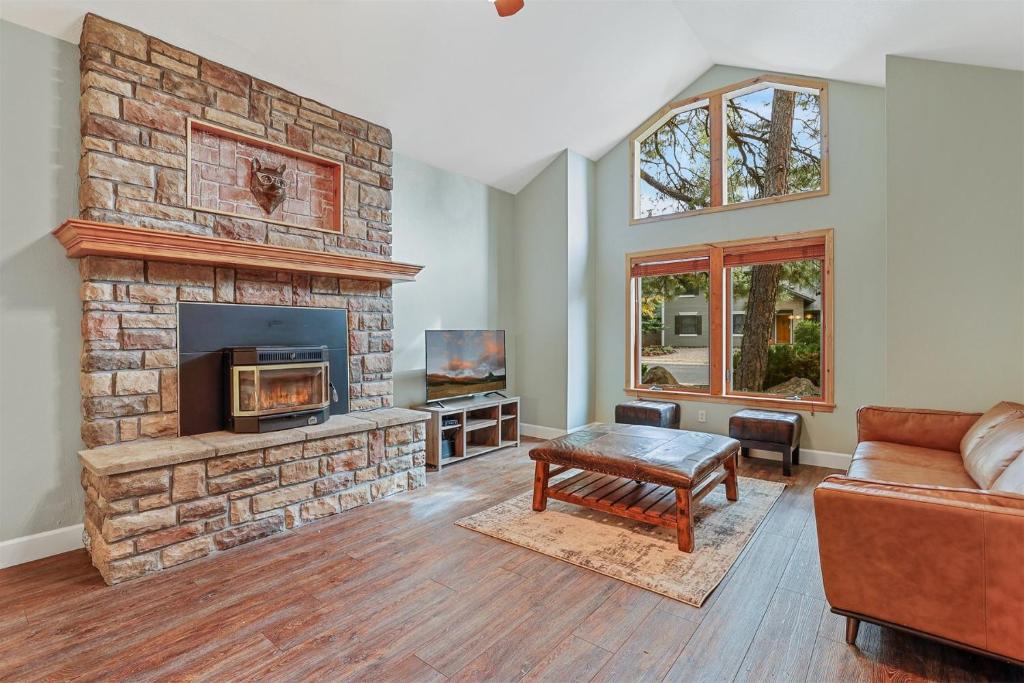 ein Wohnzimmer mit einem Steinkamin und einem Sofa in der Unterkunft Bluebird Song Prime Flagstaff Location Outdoor Retreat with Fenced Yard and Firepit in Flagstaff