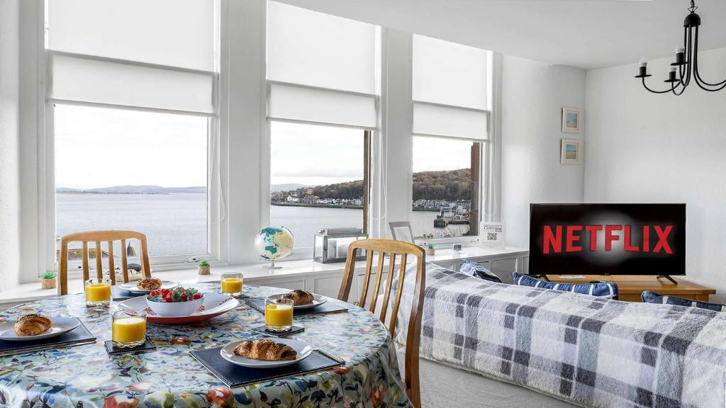 a dining room with a table with food on it at The Hidden Asset- Rothesay, Isle of Bute in Rothesay