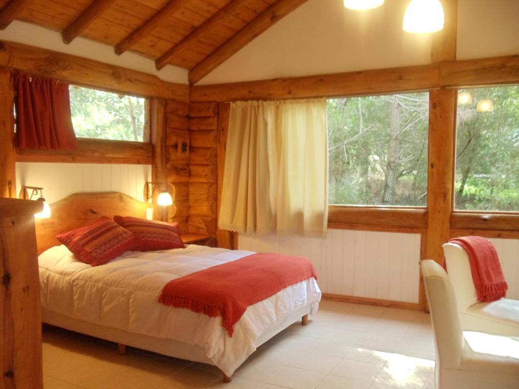 1 dormitorio con 1 cama en una habitación con ventanas en Patagonia Playa Cielo en Mar de las Pampas
