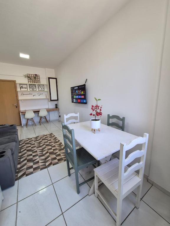 a dining room with a white table and chairs at Flat quarto e sala completo in Vitória