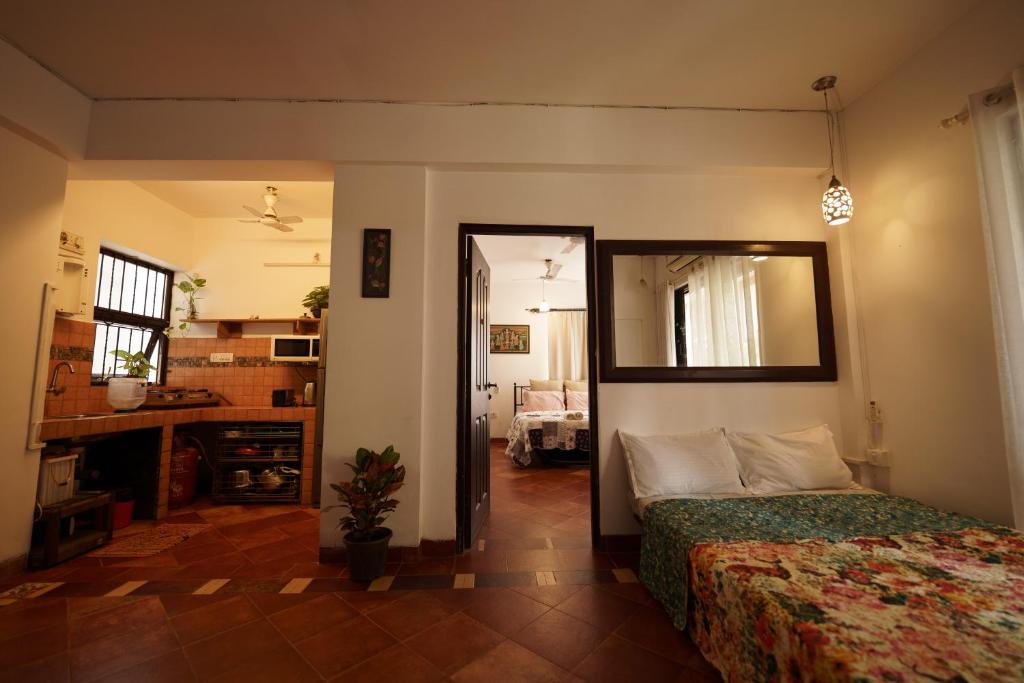 Un dormitorio con una cama y un espejo en una habitación. en AQUAVISTA at CasaPhilomena, en Calangute