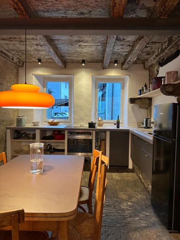 a kitchen with a wooden table and a dining room at Historische Unterkunft Casa Tre Valli in Biasca