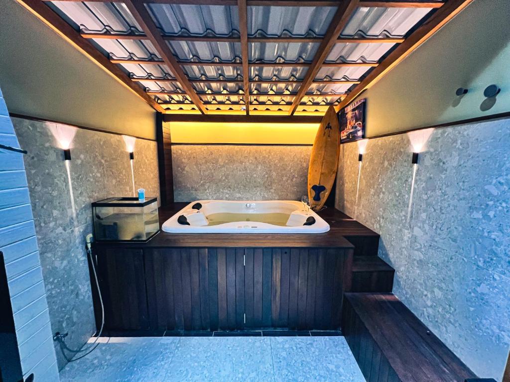 コンボリウーにあるCasa com Jacuzzi, Próximo Teleférico, GreenValley e Praia BC!のサーフボードが置かれた浴室の浴槽
