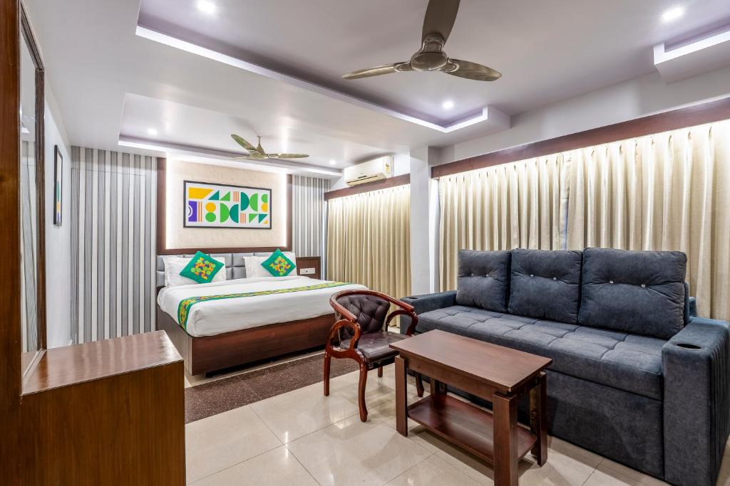 a living room with a couch and a bed at Treebo Marina Grand, Railway station in Visakhapatnam