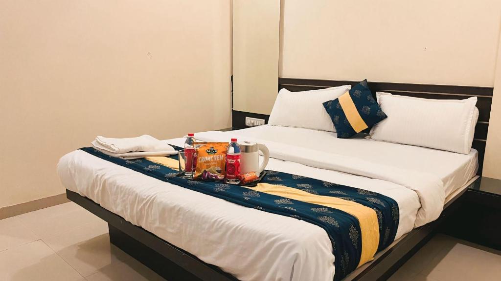 a hotel room with two beds with a tray of food at Hotel Shri Govind in Shirdi
