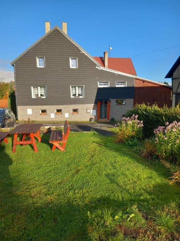 una casa con mesa de picnic y sillas en el patio en Apartmán na kopečku, en Pernink