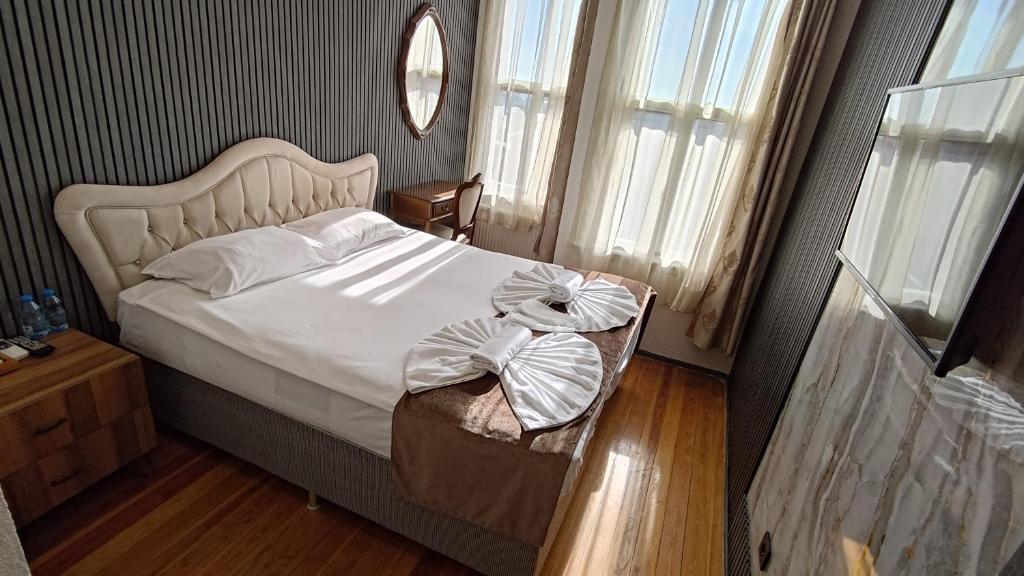 een slaapkamer met een wit bed met een groot hoofdeinde bij Nuray Hotel in Istanbul