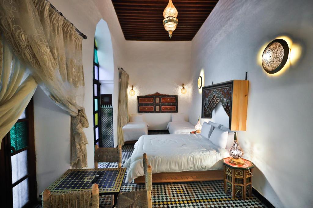 a bedroom with a bed in a room with a window at Dar Elinor Fez in Fès