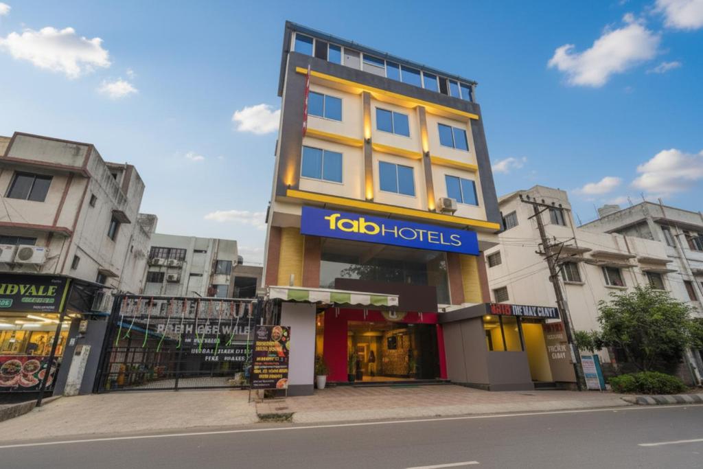 un edificio alto amarillo con un cartel en él en Via The Max Glory, en Indore