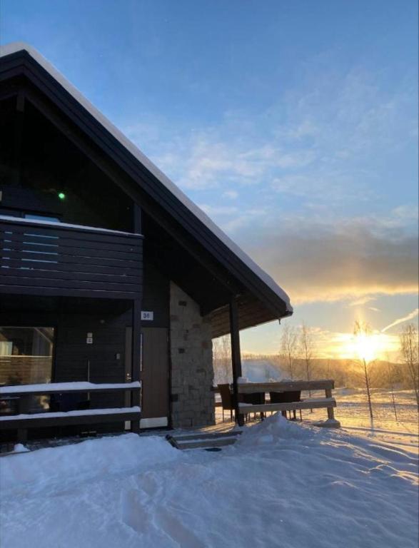 a log cabin with a bench in the snow at Himos Mökki in Jämsä