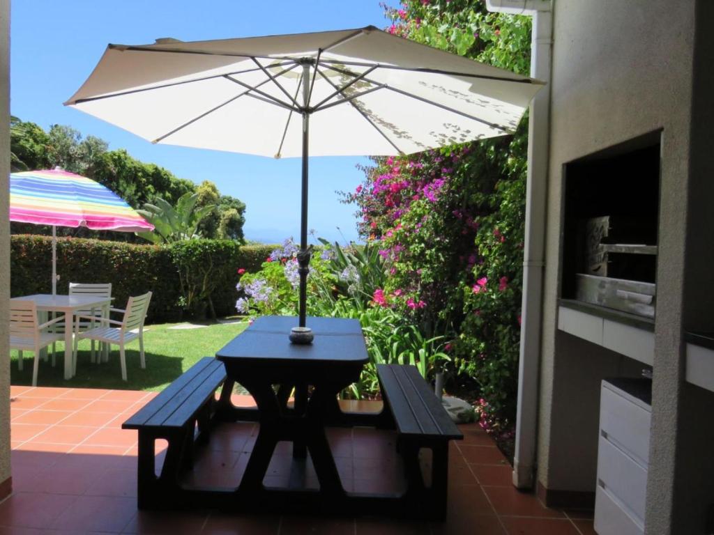 a picnic table with an umbrella on a patio at No. 1 Arrowood, Plettenberg Bay in Plettenberg Bay