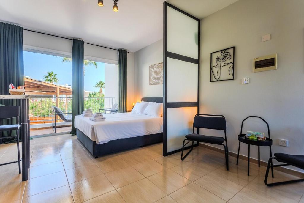 a bedroom with a bed and a large mirror at estéa - Peyia's Pearl - Holiday Studio in Peyia