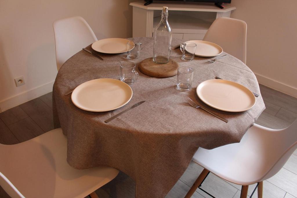 a table with plates and wine glasses on it at Escapade au Mont St Michel in Pleine-Fougères