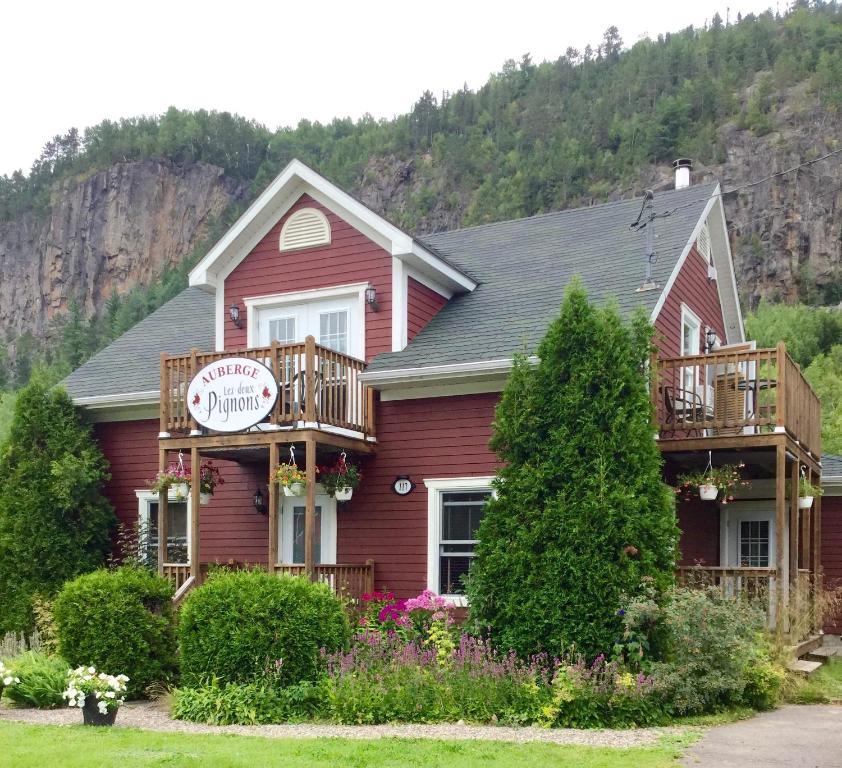 a red house with a sign on it at B&B Les Deux Pignons in Petit-Saguenay