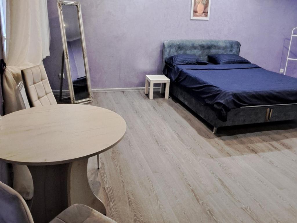 a bedroom with a bed and a table at Студия в центре города in Kryvyi Rih