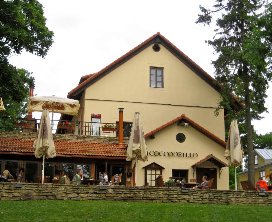 ein Restaurant mit Sonnenschirmen vor einem Gebäude in der Unterkunft Viimsi manor guesthouse Birgitta in Tallinn