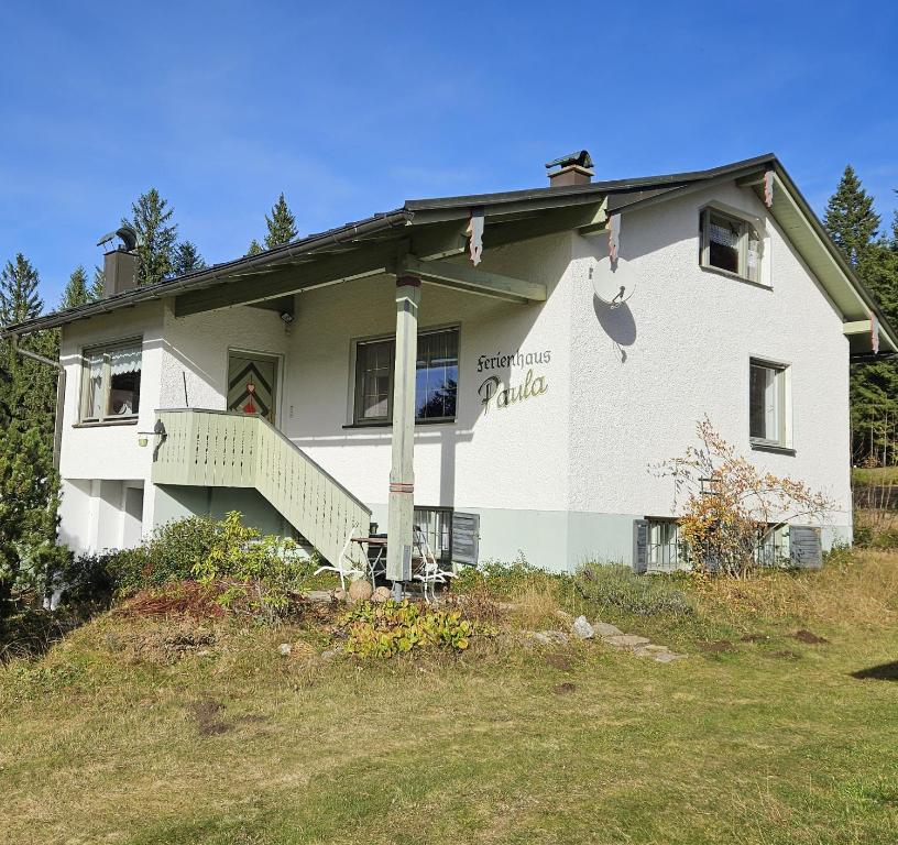 a white house with a porch on a hill at Arber Haus Paula in Bayerisch Eisenstein