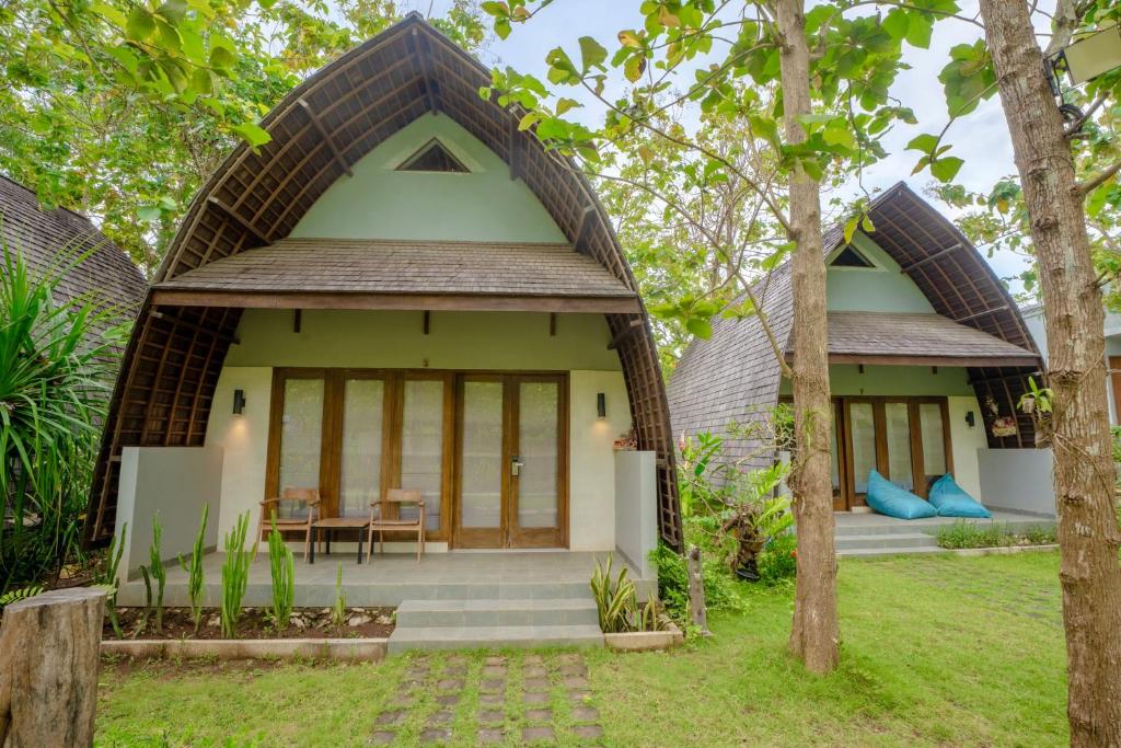 Kayu Jati Cottages في Toyapakeh: منزل صغير بسقف من القش