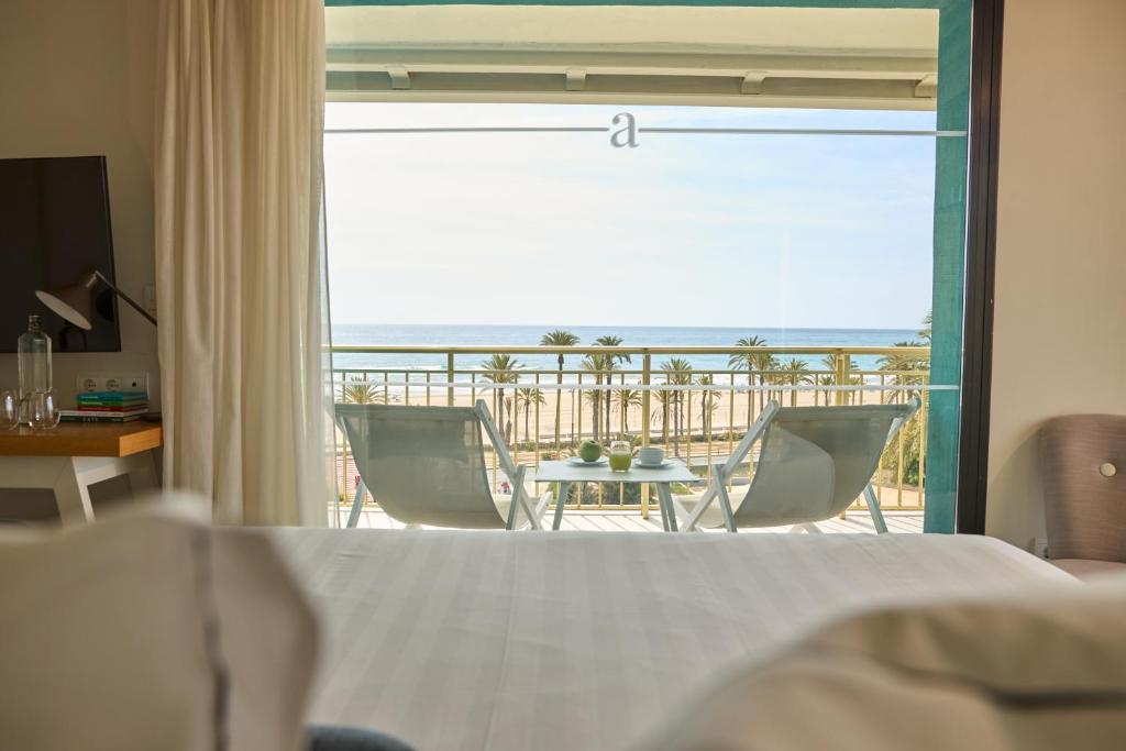 a bedroom with a bed and a view of the ocean at Hotel Almirante in Alicante