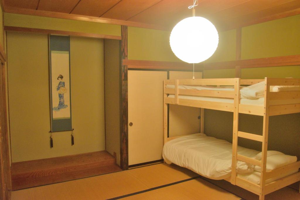 een kamer met 2 stapelbedden en een spiegel bij ゲストハウス灯 in Azumino