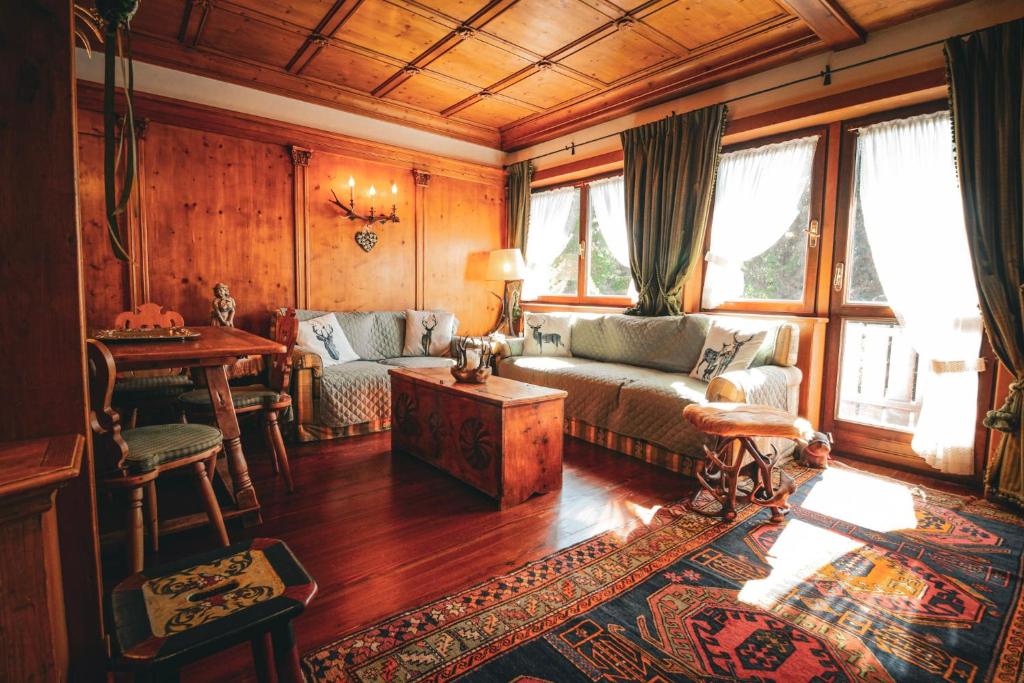 a living room with a couch and a table at Nido Ampezzano - a short walk from the center in Cortina dʼAmpezzo
