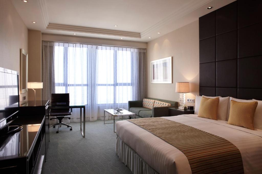 a hotel room with a bed and a desk at Courtyard by Marriott Kunshan in Kunshan