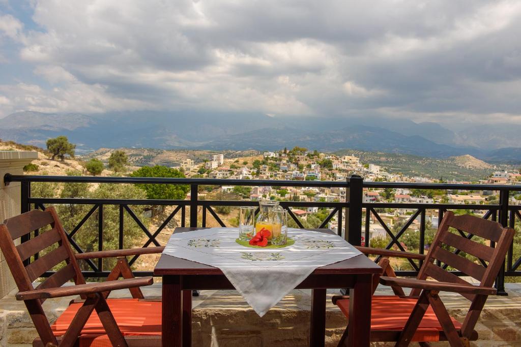 Una mesa y sillas en un balcón con vista. en Villa Dionysos - Kalamaki Holidays, en Kamilari