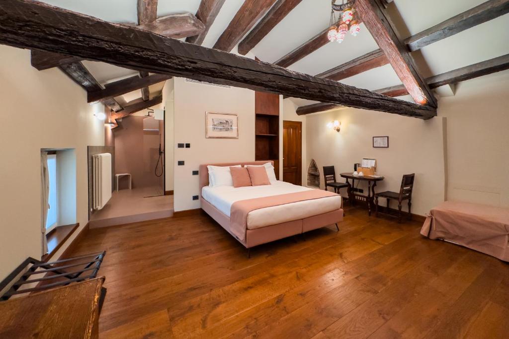 a bedroom with a bed and a table in a room at 1448 Antica Dimora Al Merlo Bianco in Cividale del Friuli