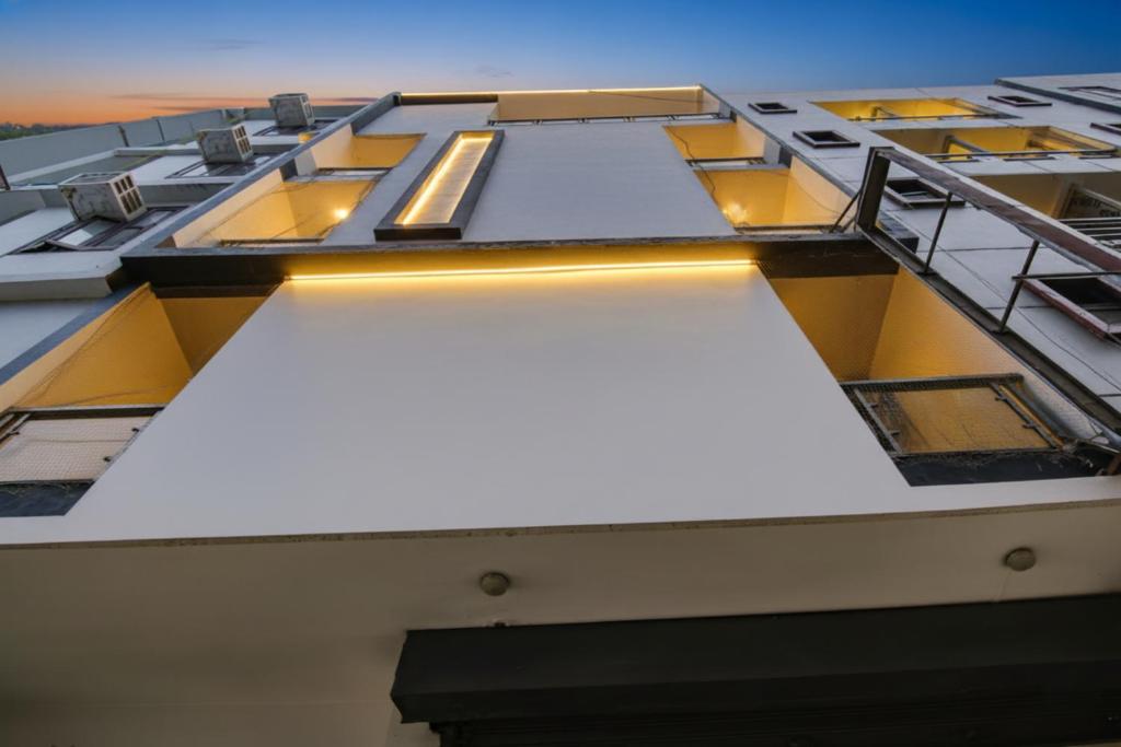 una vista della facciata di un edificio con finestre gialle di Via Aerosky Inn - Nr Yashobhoomi Convention Centre a Nuova Delhi