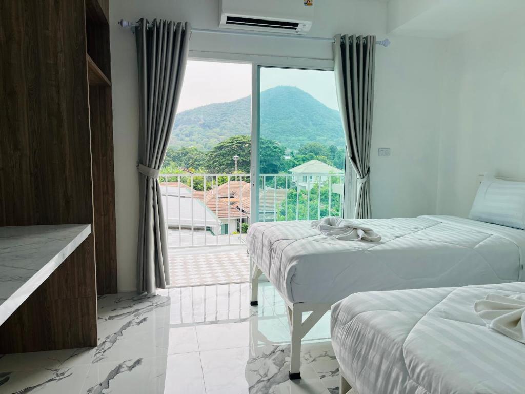 SattahipにあるDm สัตหีบ อู่ตะเภา สนามกีฬาราชนาวีสัตหีบのベッドが2つと大きな窓がある寝室