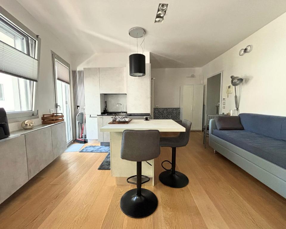 Una cocina y una sala de estar con una mesa y un sofá. en Bilocale centralissimo a due passi dal mare - CN023, en Cesenatico