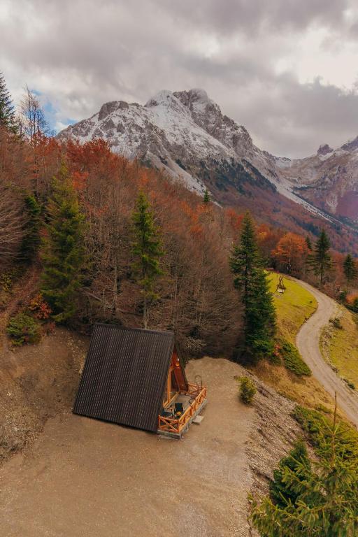 an orange truck parked in a field near a mountain at Komovi Luxury Sunset in Andrijevica