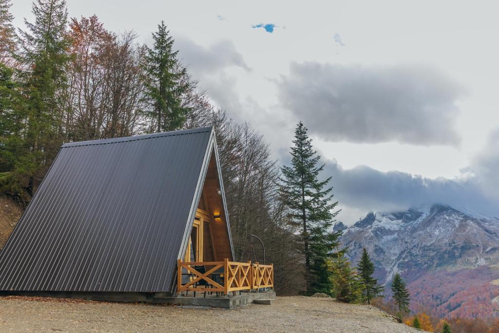 een klein hutje in het bos met uitzicht op een berg bij Komovi Luxury Sunset in Andrijevica