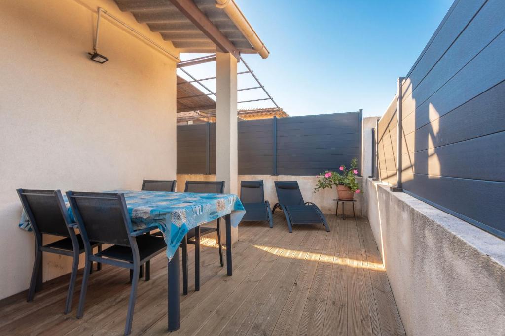 a patio with a table and chairs on a deck at Les Sables in Bormes-les-Mimosas