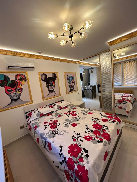 a bedroom with a bed with red flowers on it at Central Park Rentals in Chişinău