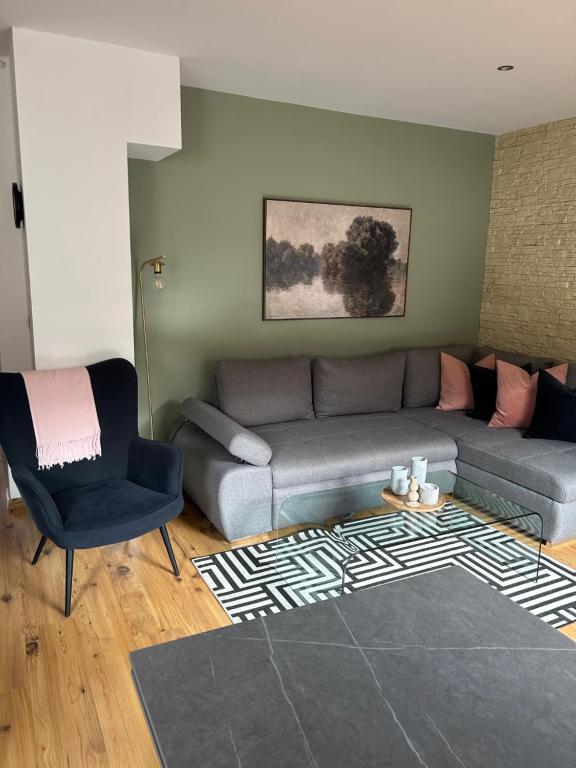 a living room with a couch and a chair at Apartament 007A pod Śnieżką in Karpacz