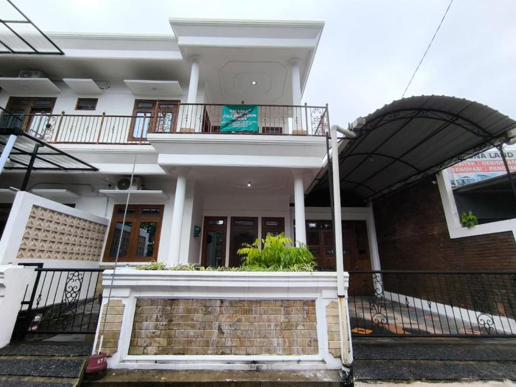 een wit gebouw met een trap en een balkon bij Daffodil House Proper Guest House Near Malioboro in Demangan