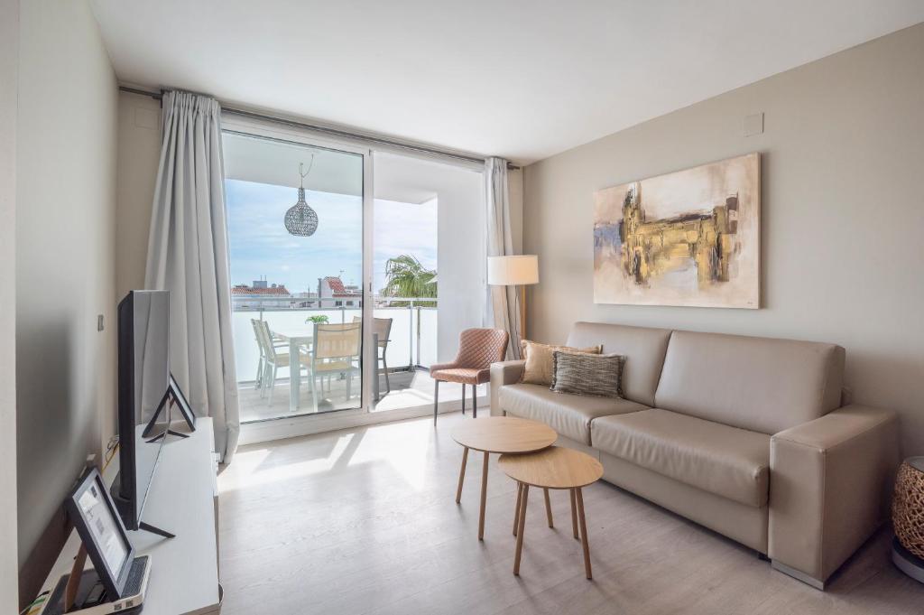a living room with a couch and a table at Sitges Spaces Oasis Penthouse 3 Bedroom, 2 Bathroom, Terrace, Pool, Sleeps up to 6 in Sitges