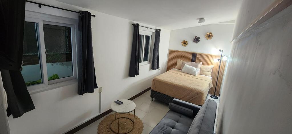 una piccola camera da letto con un letto e un divano di Casa Mariscal a Guatemala