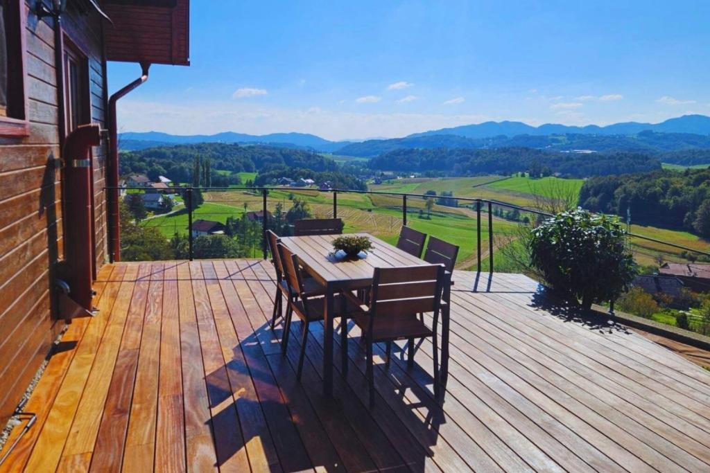 een houten terras met een tafel en stoelen erop bij Brioni Hills - Premium Escape in Šmarje pri Jelšah