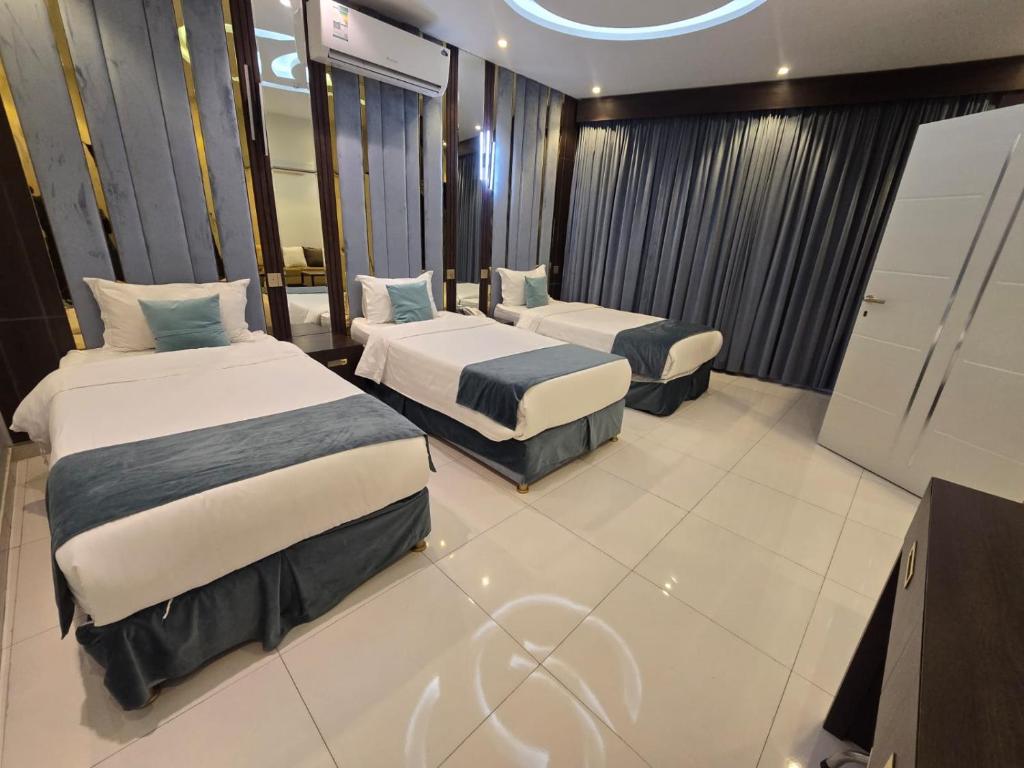 a hotel room with two beds and a television at الجوهرة سويت للشقق المخدومة in Shahār