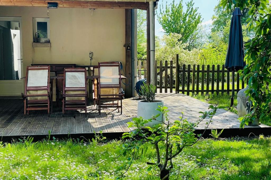 un patio avec des chaises, une table et un parasol dans l'établissement Villa paisible avec piscine, à Bercloux